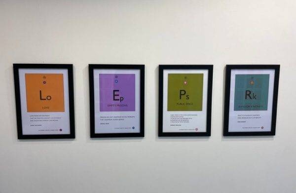 Four black frames on a white wall. They each contain a different utopian chemistry symbol.